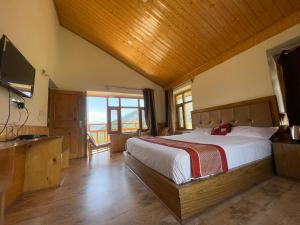 ein Schlafzimmer mit einem großen Bett und einem TV in der Unterkunft Heavens retreat,Club nirvana stays in Vashisht