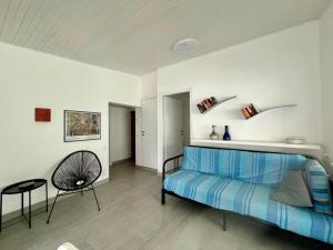 um quarto com uma cama azul e uma cadeira em Casa Azzurra em Germignaga