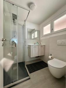 uma casa de banho com um chuveiro, um WC e um lavatório. em Casa Azzurra em Germignaga