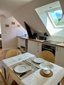 a kitchen with a table with two plates on it at Le cocon, T2, hypercentre in Cherbourg en Cotentin