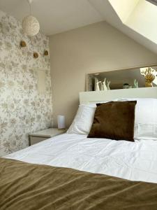 a bedroom with a white bed with a brown pillow at Le cocon, T2, hypercentre in Cherbourg en Cotentin