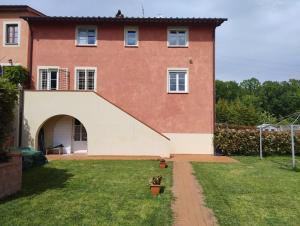 a large brick house with an archway in a yard at Casa Claudia in Capannori