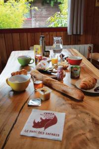 a wooden table with food and bread on it at Cerza Safari Lodge in Hermival-les-Vaux