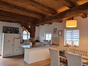 cocina con techos de madera, mesa y sillas en Ferienhaus im Seedorf im Münsterland, en Warendorf