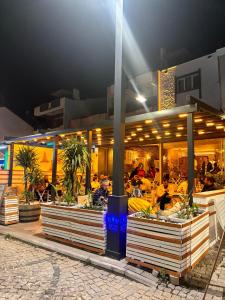 a restaurant with people sitting at tables at night at Hotel Barba in Urla