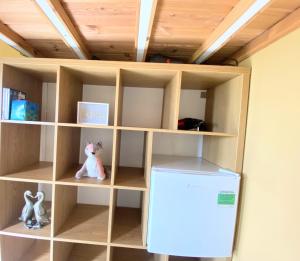 a book shelf with a refrigerator in a room at Blair Tiny House with Private Hot Tub - Pet Friendly- Fife - Loch Leven - Lomond Hills in Dunfermline