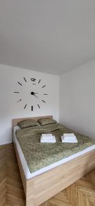 a bedroom with a bed with a clock on the wall at Apartament przy Lipowej in Białystok