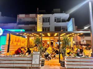 un grupo de personas sentadas en un restaurante por la noche en Hotel Barba, en Urla