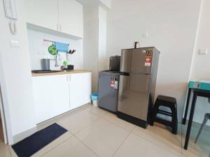 a kitchen with a stainless steel refrigerator and a table at Plaza @ Kelana Jaya 2 Bedroom House NEW 2024! in Petaling Jaya
