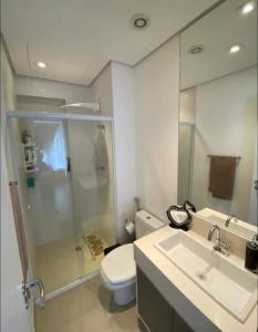 a bathroom with a toilet and a sink and a mirror at Cantinho da vovó, studio alto padrão in Santos