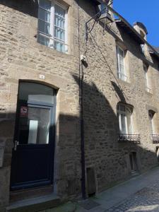 a brick building with a blue door and a window at Appartement entier centre historique DINAN in Dinan