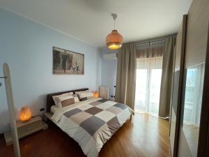 um quarto com uma cama com colcha xadrez em SEA4USALERNO seafront em Salerno