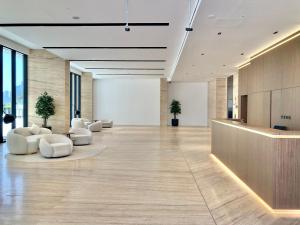 an office lobby with white chairs and a reception desk at LUXURY 2 BR APARTMENT IN JADDAF By 0 10 AQUA in Dubai