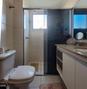 een badkamer met een douche, een toilet en een wastafel bij Apto espaçoso no Aquarius in São José dos Campos +47 foto's