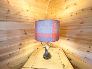 a lamp sitting on a wooden table in a room at Pond View Pod 1 with Outdoor Hot Tub - Pet Friendly - Fife - Loch Leven - Lomond Hills in Kelty
