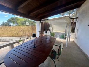 einen Holztisch auf einer Terrasse mit einem Zelt in der Unterkunft Trullo Pasquale in Selva di Fasano