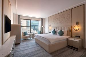 a hotel room with a bed and a television at Kempinski Hotel Amman in Amman