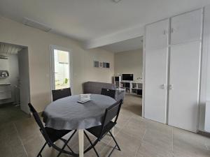 uma mesa de jantar e cadeiras num quarto em Maison * 2/4 pers* Jard sur Mer em Jard-sur-Mer