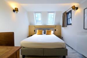 um quarto com uma cama grande e almofadas amarelas em Les Tanneurs em Namur