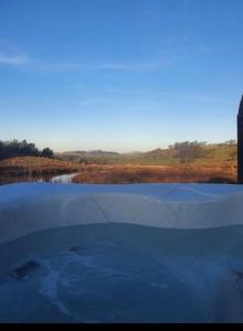 a reflection of a pool of water in a field at Pond View Pod 1 with Outdoor Hot Tub - Pet Friendly - Fife - Loch Leven - Lomond Hills in Kelty