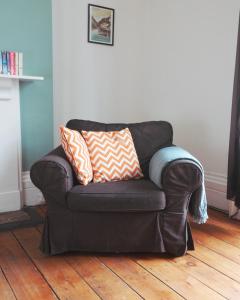 Un sofá de cuero negro con dos almohadas. en Westbourne Place Rooms - by Clifton Short Lets, en Bristol