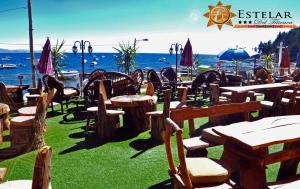 a group of tables and chairs in front of the ocean at HOTEL ESTELAR del TITICACA in Copacabana