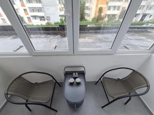ピテシュティにあるSweet homeの2つの窓がある部屋に椅子2脚