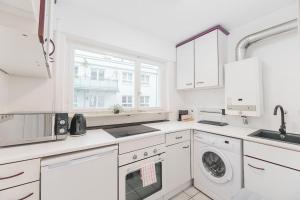 una cucina bianca con lavandino e lavastoviglie di S02 Exclusive Stuttgart City 2Room Dream Apartment a Stoccarda