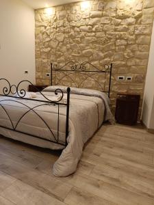 Bett in einem Zimmer mit einer Steinmauer in der Unterkunft Il Casale Di Ginetto in Cascia