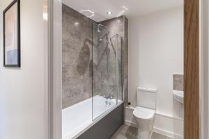 y baño con bañera, aseo y ducha. en Host & Stay - 52 Waterside Place, en Taunton