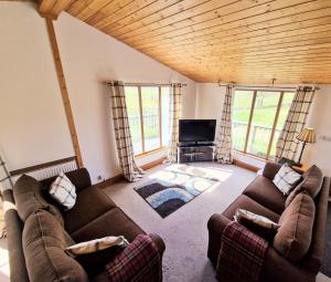 a living room with two couches and a television at Torridon 12 with Private Hot Tub - Fife - Loch Leven - Lomond Hills in Kelty