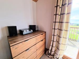 a room with a dresser with a window and a dresser with speakers at Torridon 12 with Private Hot Tub - Fife - Loch Leven - Lomond Hills in Kelty