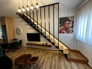 a living room with a staircase with a television at Ethra Suite 1 in Volos