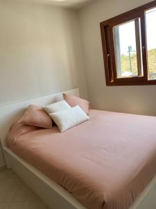 a bedroom with a bed with two pillows on it at Cabo Negro-Lilac's Garden in Cabo Negro
