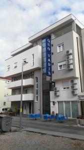 a white building with blue chairs in front of it at Hotel Quo Vadis in Međugorje
