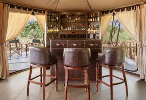 een bar in een kamer met 2 barkrukken bij TARANGIRE KURO TREETOP LODGE in Manyara