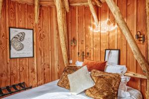a bedroom with a bed in a wooden wall at La Cabane Korrigans in Gommené