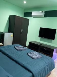 una camera con letto con lenzuola blu e TV di Mipiace a Kamala Beach