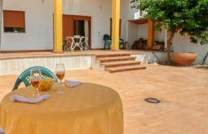a yellow table with two glasses of wine on it at El Retiro Vivienda Rural in Villanueva del Rey