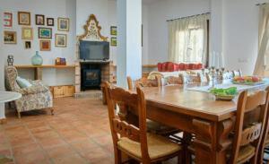 El Retiro Vivienda Rural في Villanueva del Rey: غرفة معيشة مع طاولة خشبية وأريكة