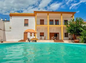 eine Villa mit einem Swimmingpool vor einem Haus in der Unterkunft El Retiro Vivienda Rural in Villanueva del Rey
