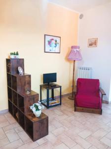 een woonkamer met een rode stoel en een tafel bij Borgo San Savino in San Savino