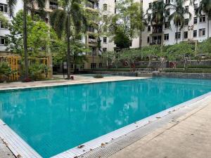 a large blue swimming pool in front of a building at Cozy 4BR 7Pax MMU Cyberjaya University Tamarind Square in Cyberjaya