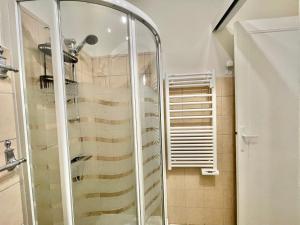 La salle de bains est pourvue d'une douche avec une porte en verre. dans l'établissement Le Petit Magellan by Welcome to Cannes, à Cannes