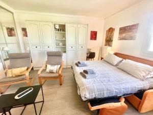 a bedroom with a bed and a couch and chairs at Le Petit Magellan by Welcome to Cannes in Cannes