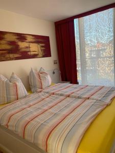 a bed with a striped comforter in a bedroom at Casa Cinzia Lucia in Eckernförde