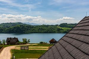 uma vista para um lago a partir de uma casa em Stylchyn Park - Apartament z Widokiem na Jezioro Czorsztyńskie em Kluszkowce