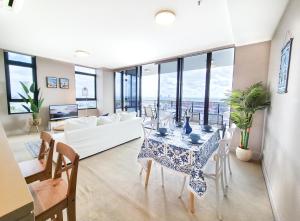 uma sala de estar com um sofá branco e uma mesa em Holiday Style 2 BRStudy Apartment in Olympic Park em Sydney
