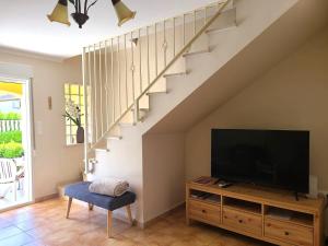 uma sala de estar com uma televisão e uma escada em Bungalow Aldea del Mar em Els Poblets
