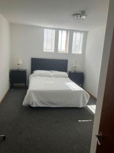 a bedroom with a white bed and two night stands at Luna Church Conversion 1 in Blackpool